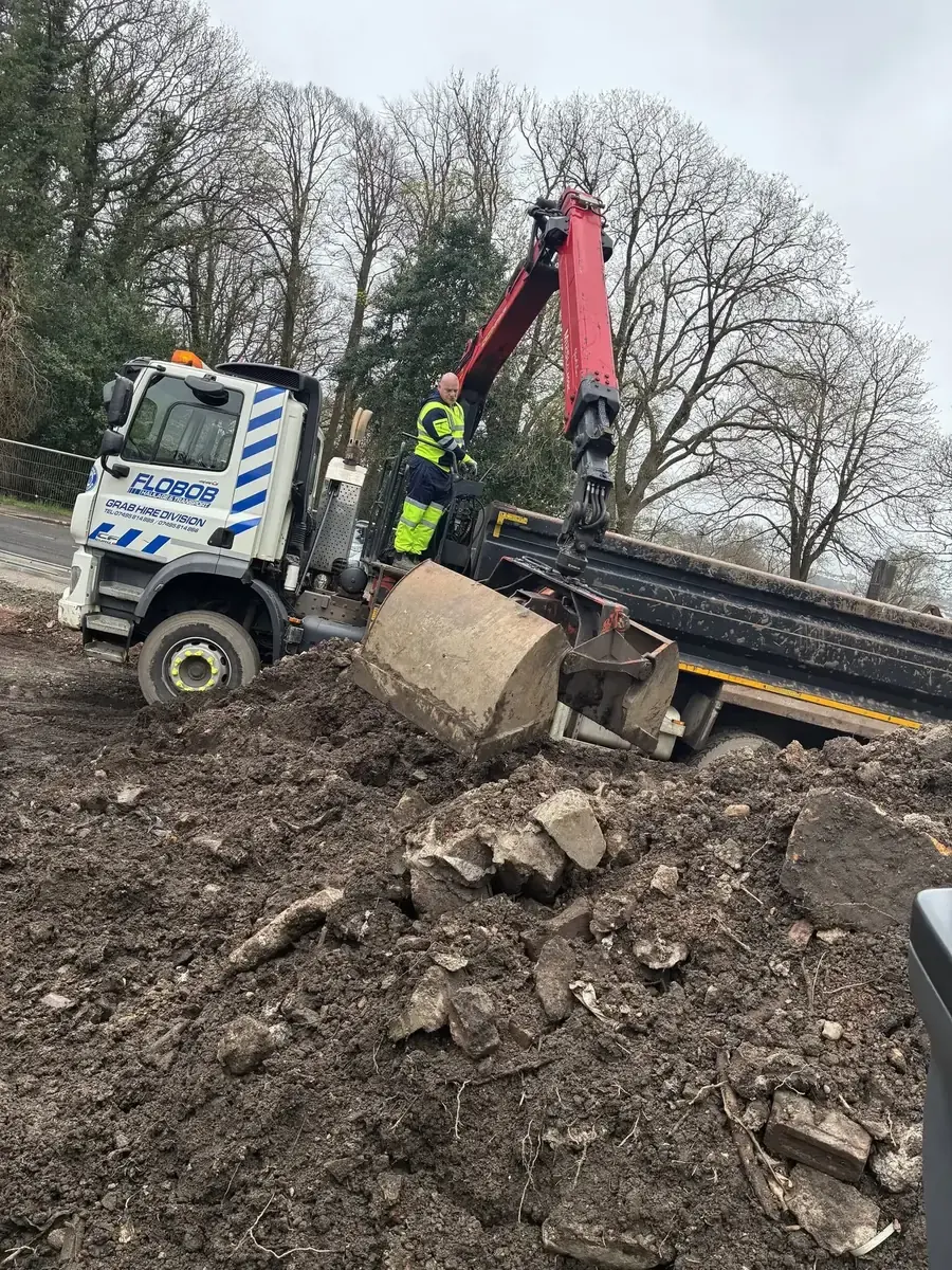 Grab Hire Scotland truck collecting material beside a property